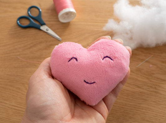 Handmade pink fabric heart sewn by hand for a beginner sewing tutorial