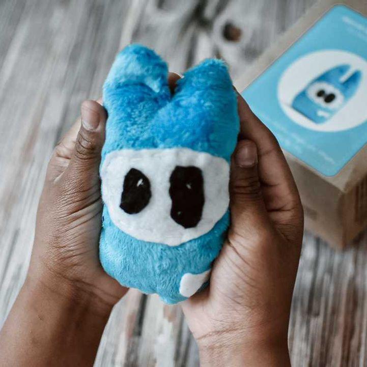 Two hands holding a handmade little monster plush, carefully crafted using the Petit Loulou DIY sewing kit for kids. A fun and creative project for young crafters.