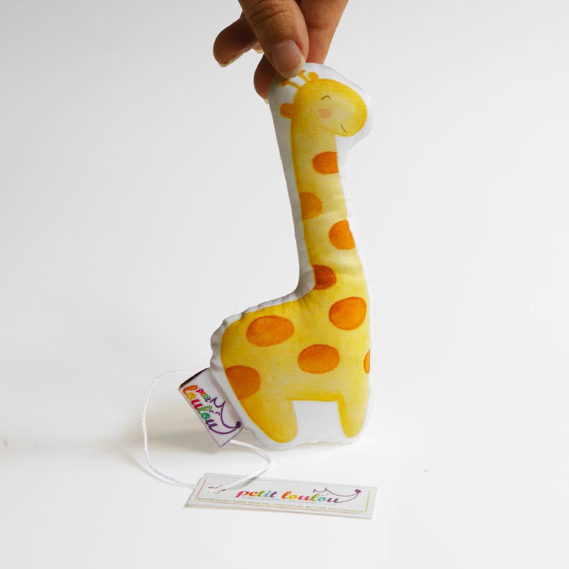 Fingers holding an handmade giraffe baby rattle